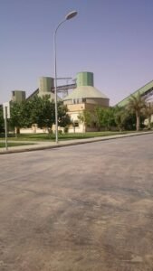 منظر لمصنع بجانب مساحات خضراء وتنسيق الحدائق في السعودية.