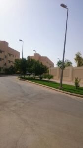 منظر لمجمع سكني يضم أشجاراً ومساحات خضراء للحفاظ على البيئة.