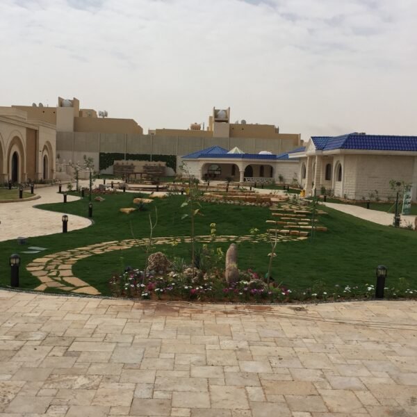 حديقة تحتوي على مسارات مبلطة وأشجار ونباتات متنوعة في تصميم منظم.